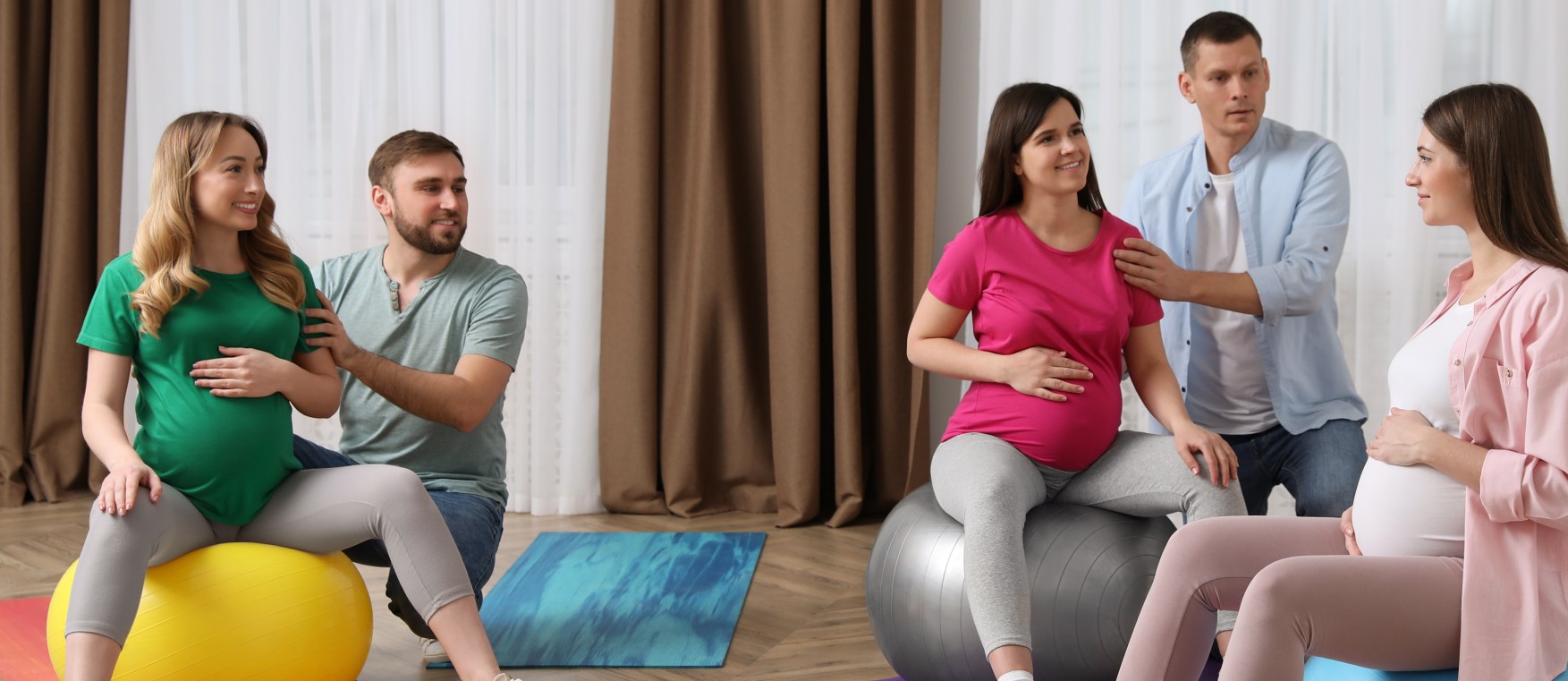 Pregnant women with men and doctor at courses for expectant parents indoors