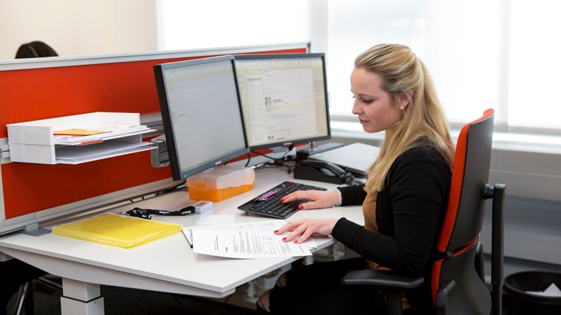 Frau arbeitet an einem Computer am Arbeitsplatz.