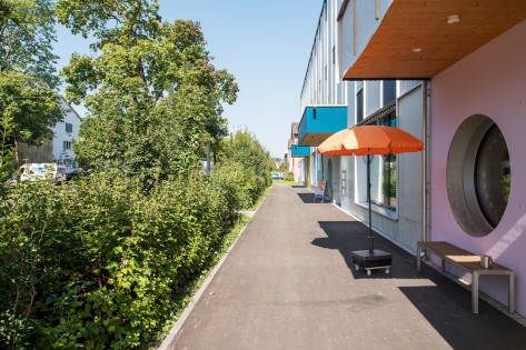 Bild der Wehntalerstrasse im Sommer mit orangenem Sonnenschirm