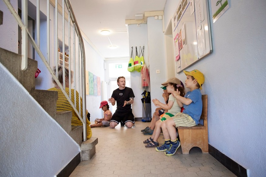 Kinder sitzen und klatschen.