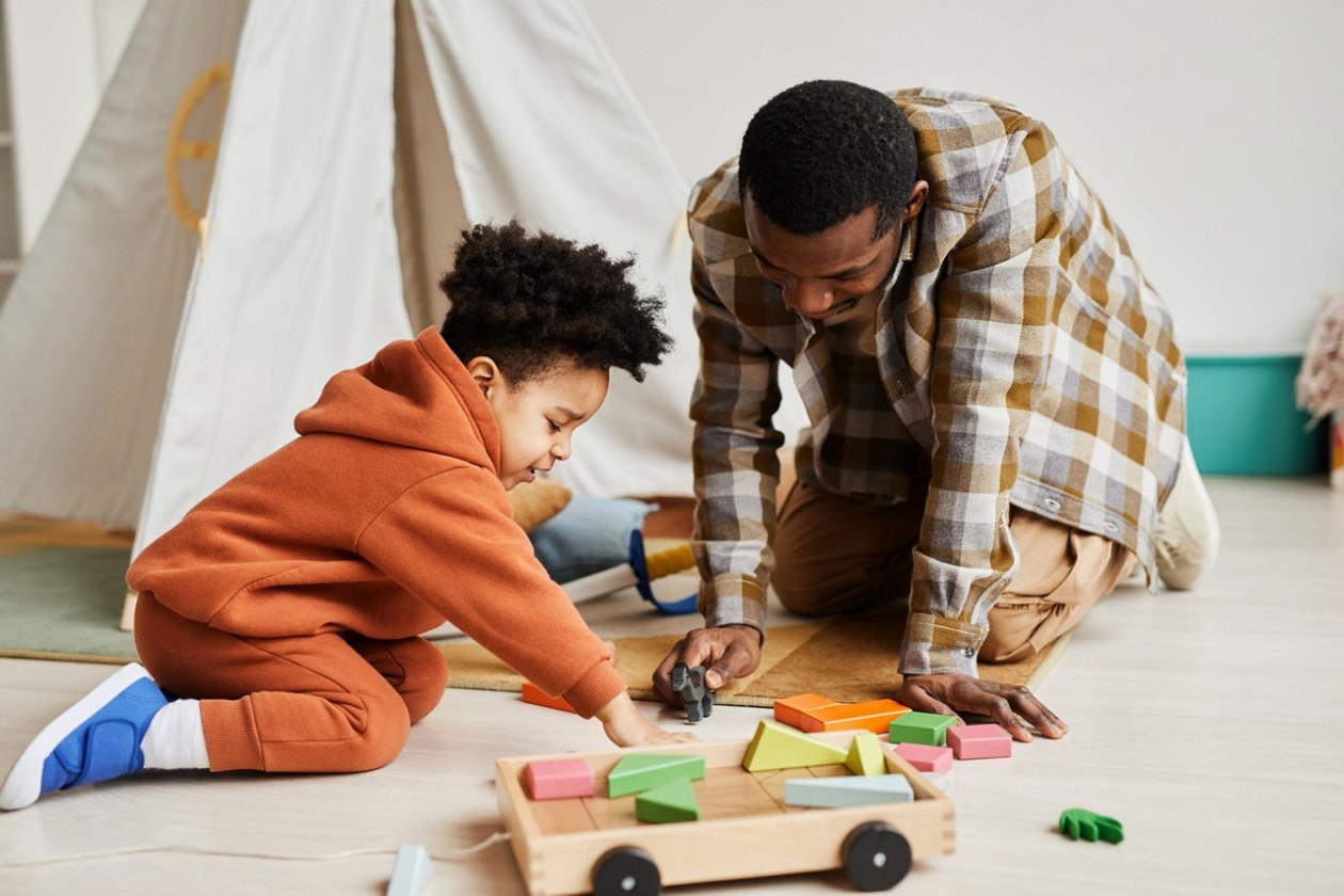 Vater und Sohn spielen mit Holzspielzeug
