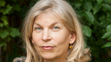 Katharina Hagena posiert vor einer Hecke.