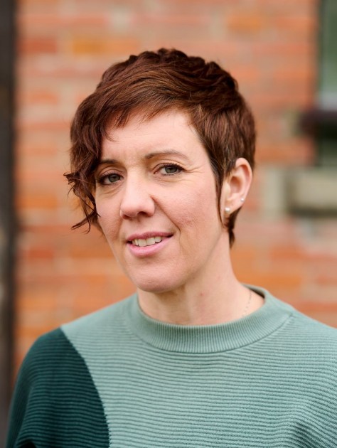 Egloff Nicole Egloff posiert vor einem Backsteinhaus.