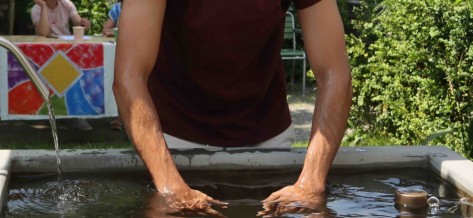 Eine Person steht im Wasser und kühlt sich die Beine ab.