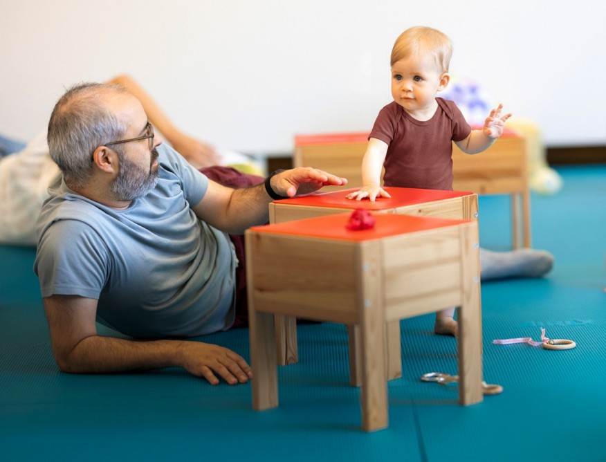 Vater mit Baby im PEKiP-Kurs der Fachschule Viventa.