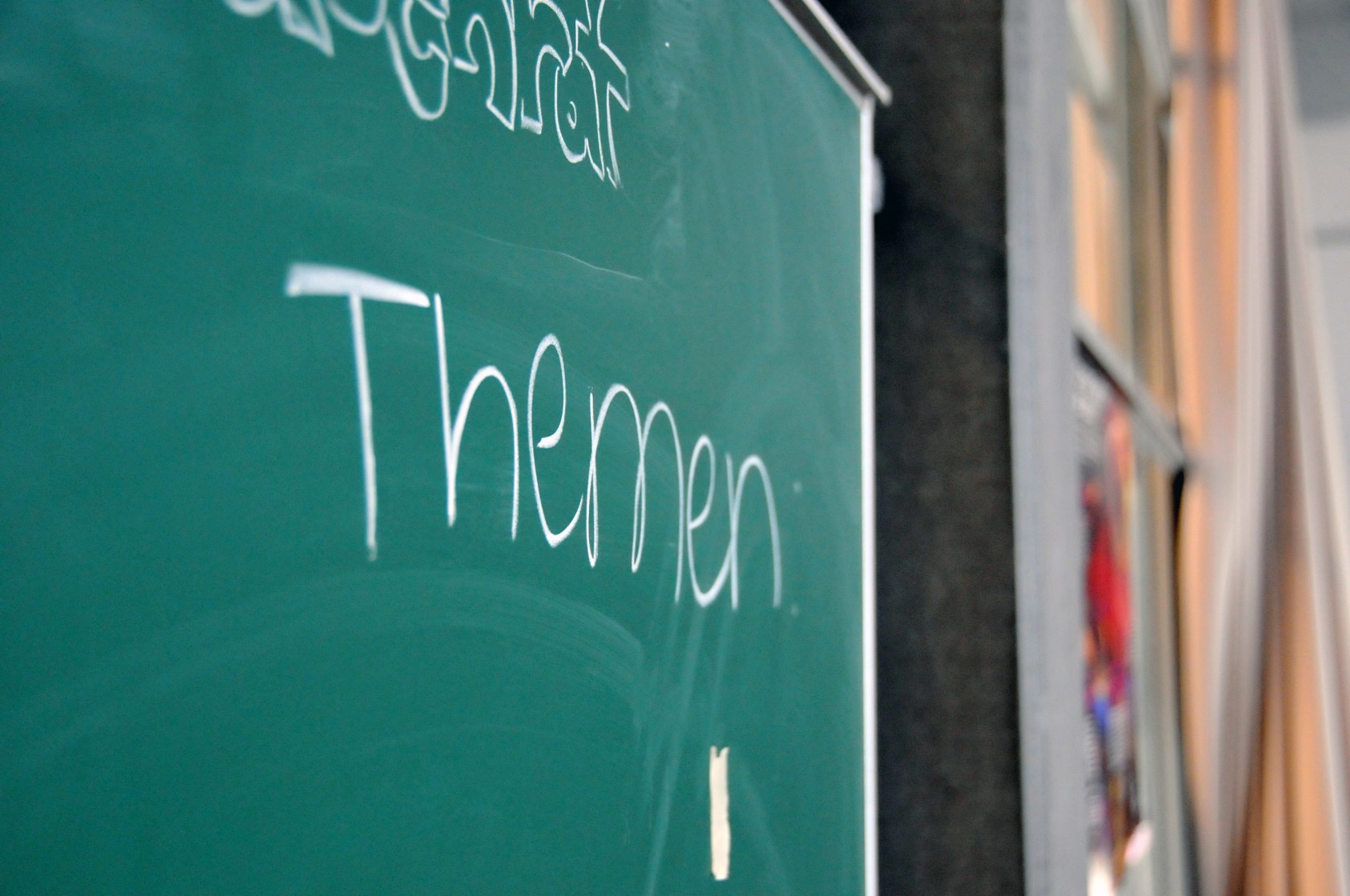 Kursleiter hält eine Präsentation in einem Klassenzimmer vor einem erwachsenen Publikum.