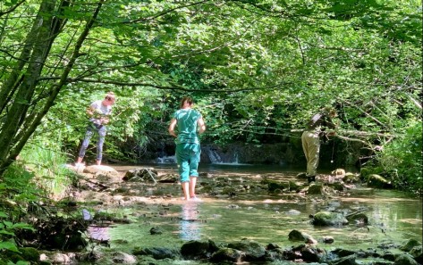 Kurs Lebensraum Wasser Teilnehmende machen Beobachtungen am Ufer und im Bach stehend.