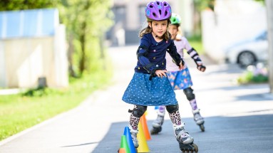 Mädchen beim Inlineskating Zwei Mädchen fahren mit Rollschuhen um Hüttchen.