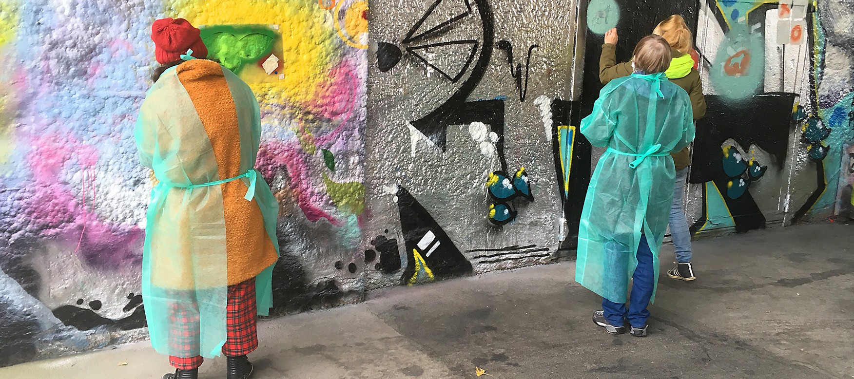 Frauen sprayen an eine Wand.