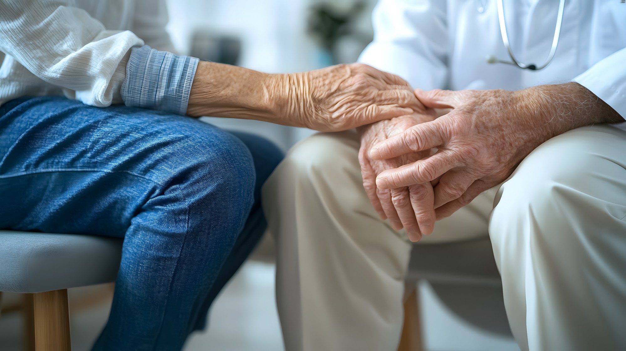 Person legt Hände über jene eines Senioren