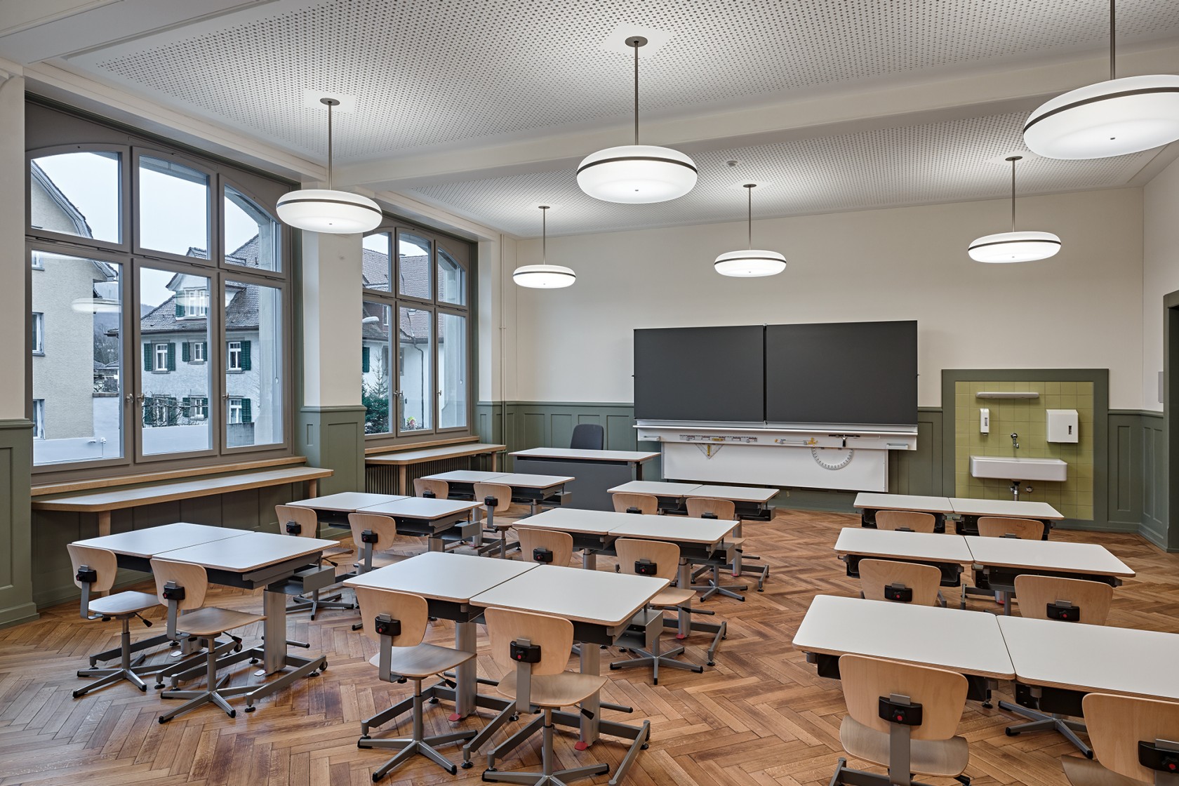 Das Foto wirft einen Blick in eines der neun Klassenzimmer mit Schulbänken und Wandtafel im Hintergrund.