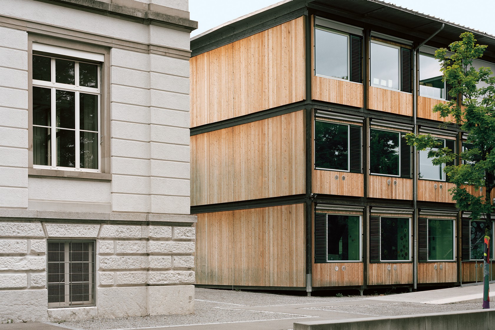 Das Foto wirft einen Blick auf einen Schulpavillon neben einem bestehenden Schulgebäude.