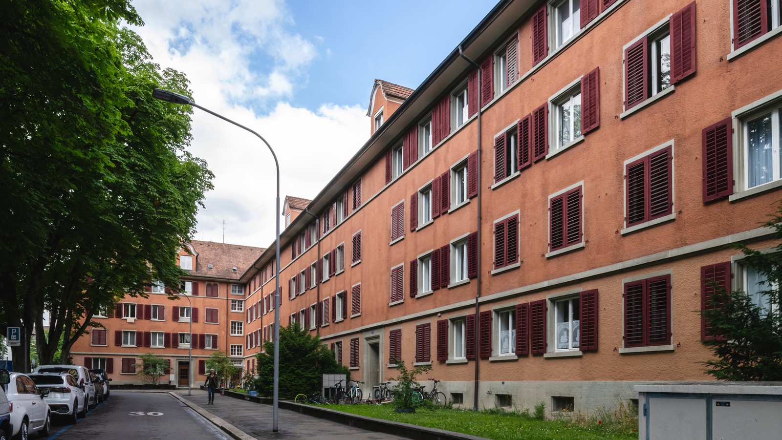 Die rote Fassade der Wohnsiedlung mit roten Fensterläden. Bild: Baugeschichtliches Archiv, Maurice K. Grünig
