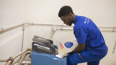 Fachfrau/-mann Betriebsunterhalt EFZ in blauer Arbeitskleidung bei der Arbeit.