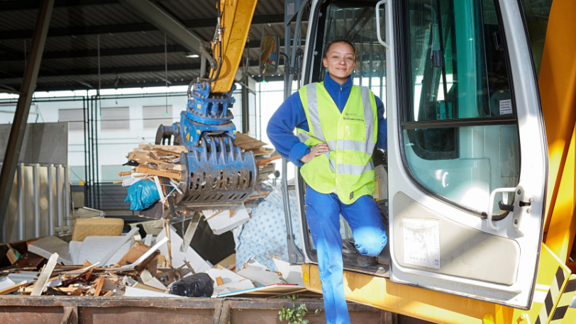 Recyclistin mit gelber Warnwese bei der Arbeit in der Kehrichtverbrennung