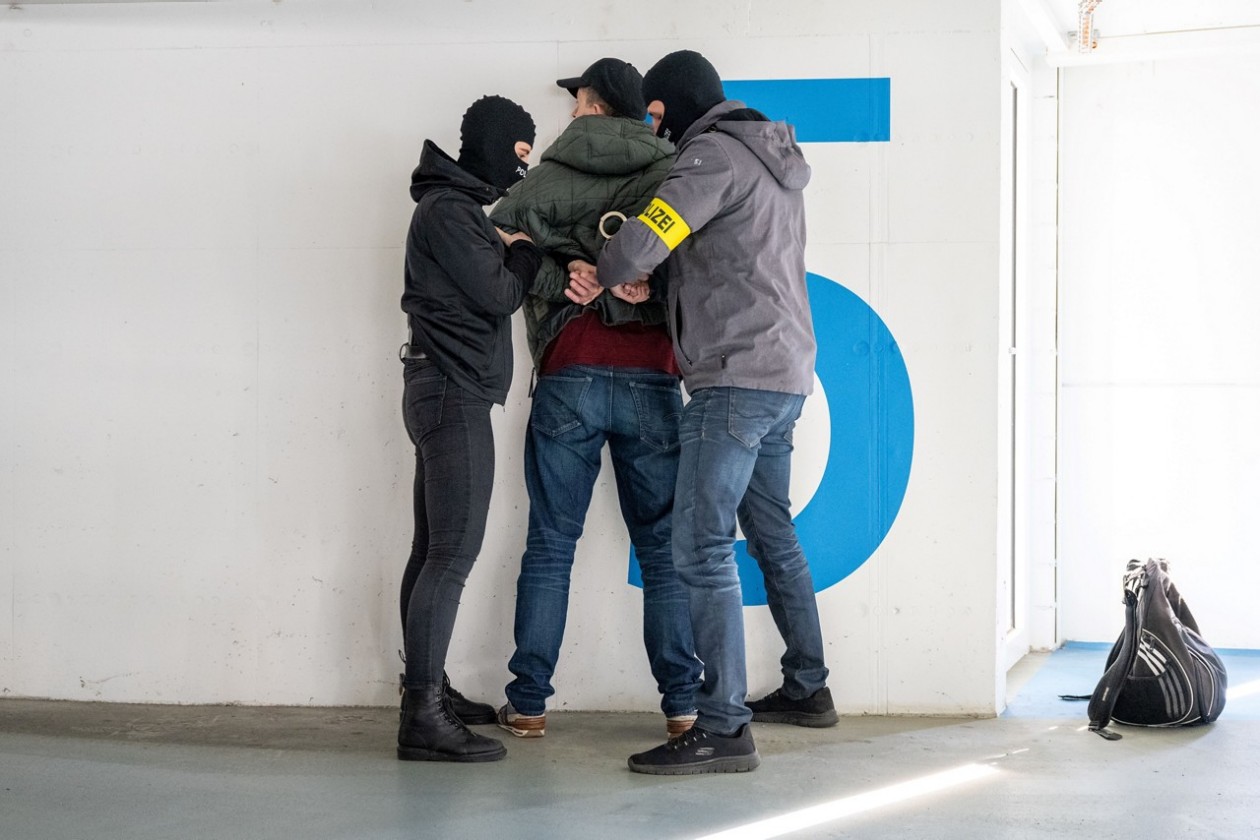 Zwei Polizisten nehmen einen Mann fest
