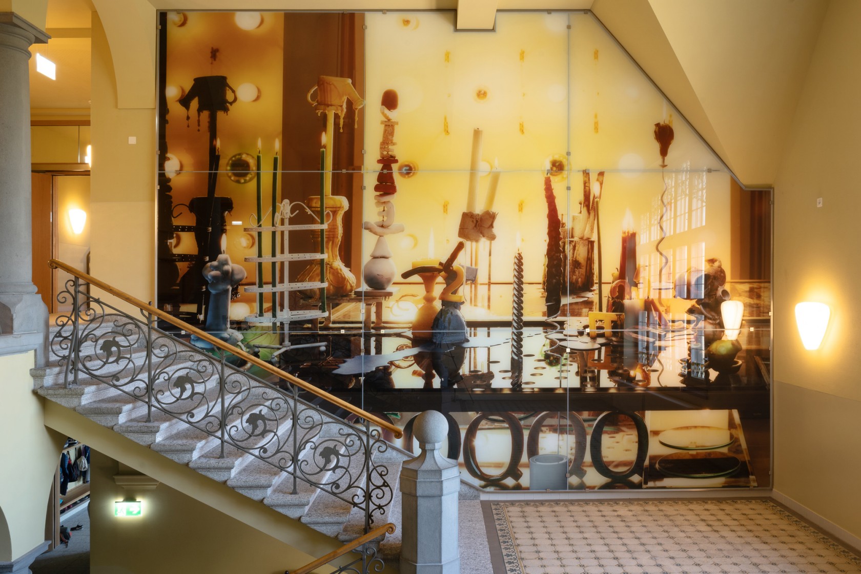 eine Kunst-und-Bau-Installation mit rauchendem Felsstein vor einer Gebäudefassade