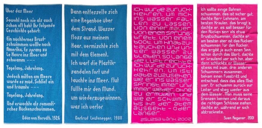 Zwei blaue und zwei rosa Badetücher mit eingewobenen Zitaten