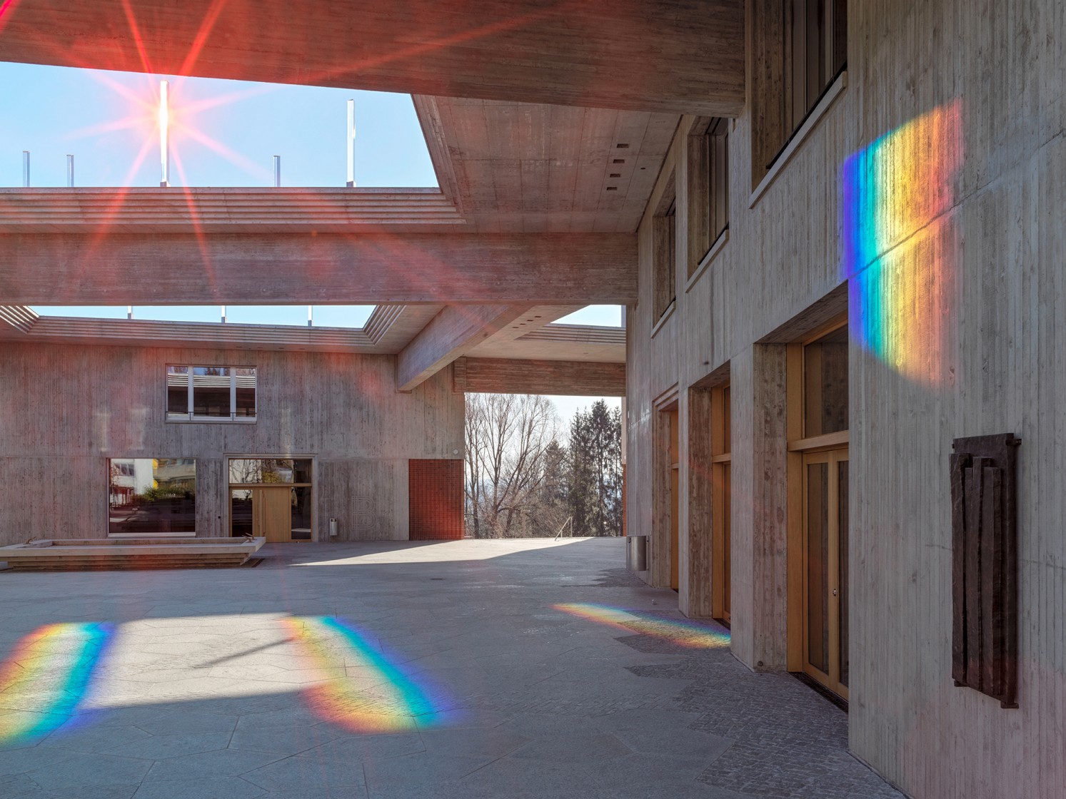 Ein Prisma auf dem Dach verteilt das Sonnenlicht auf Wände und Boden im Schulhof