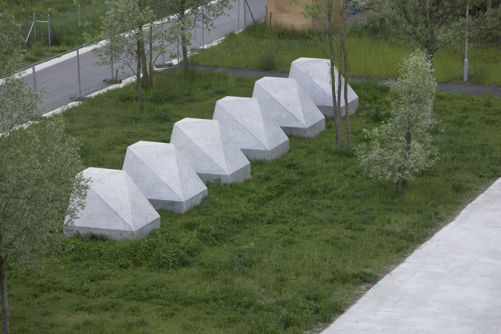 Sechs Betonpolyeder auf Wiese