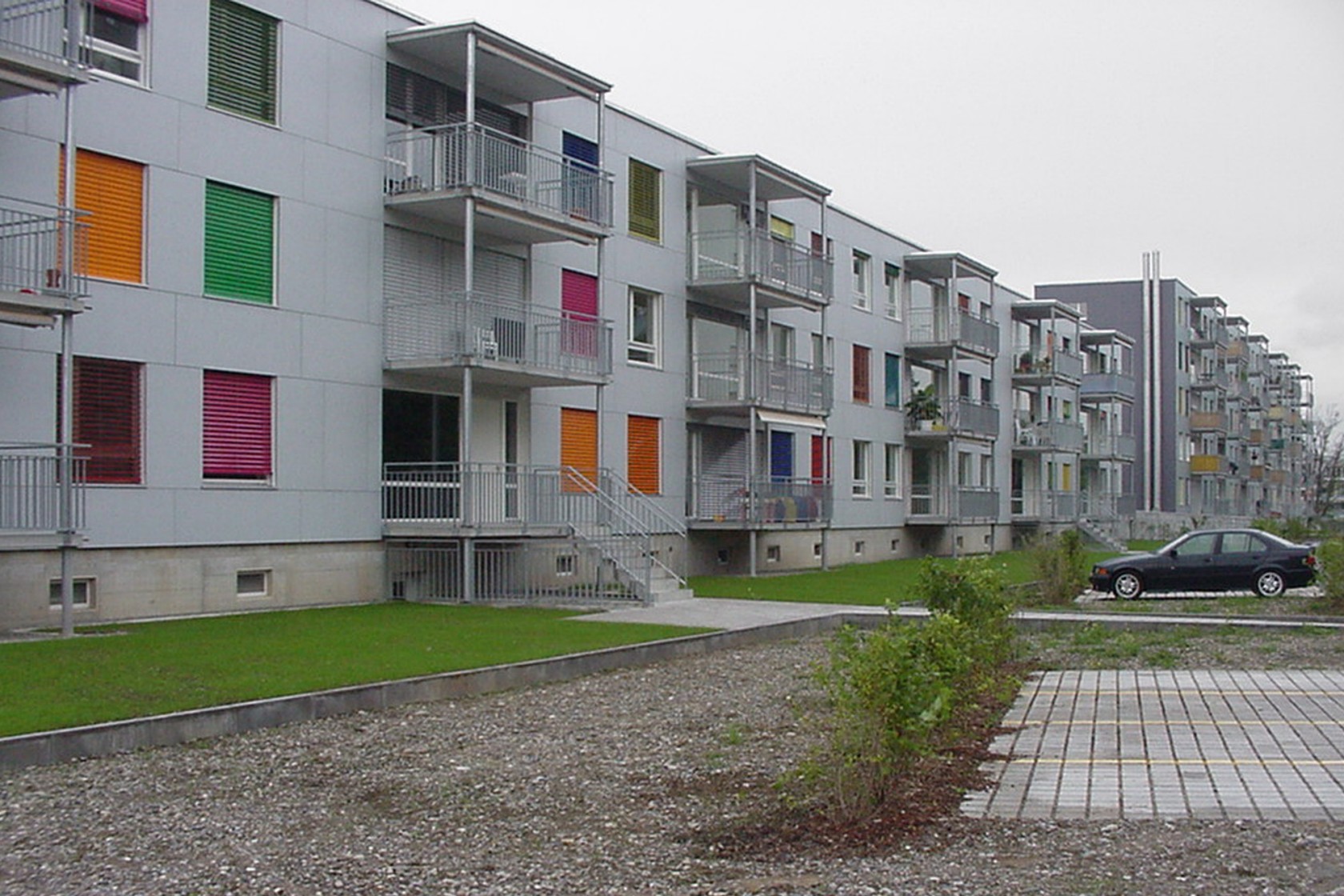 Verschiedenfarbige Lamellenstoren in den Fenstern eines Hauses