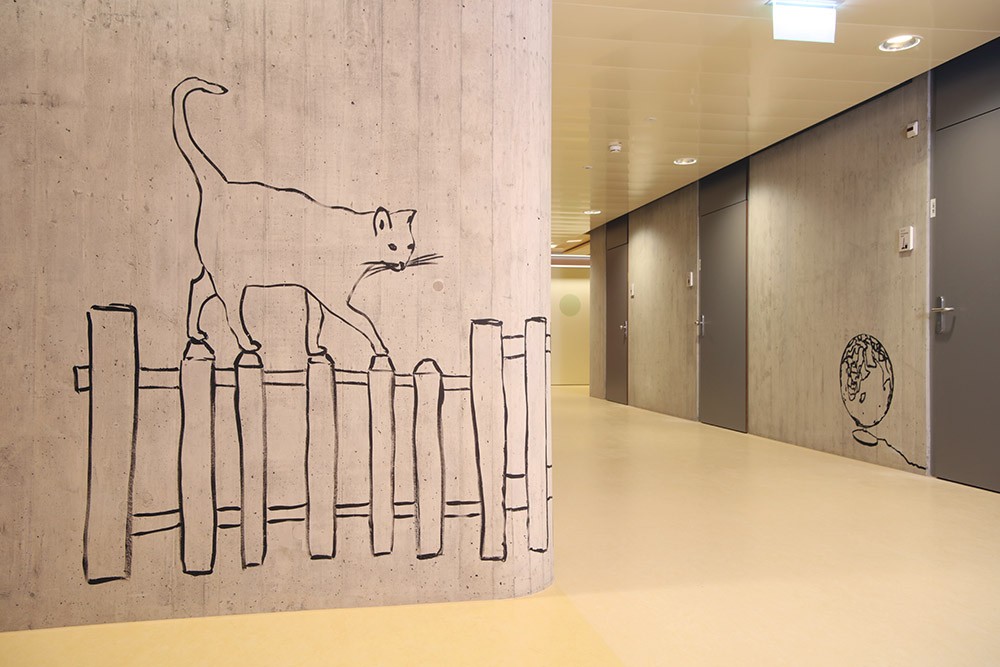 Spitalkorridor mit Wandzeichnung einer Katze auf einem Zaun und einem Globus im Hintergrund