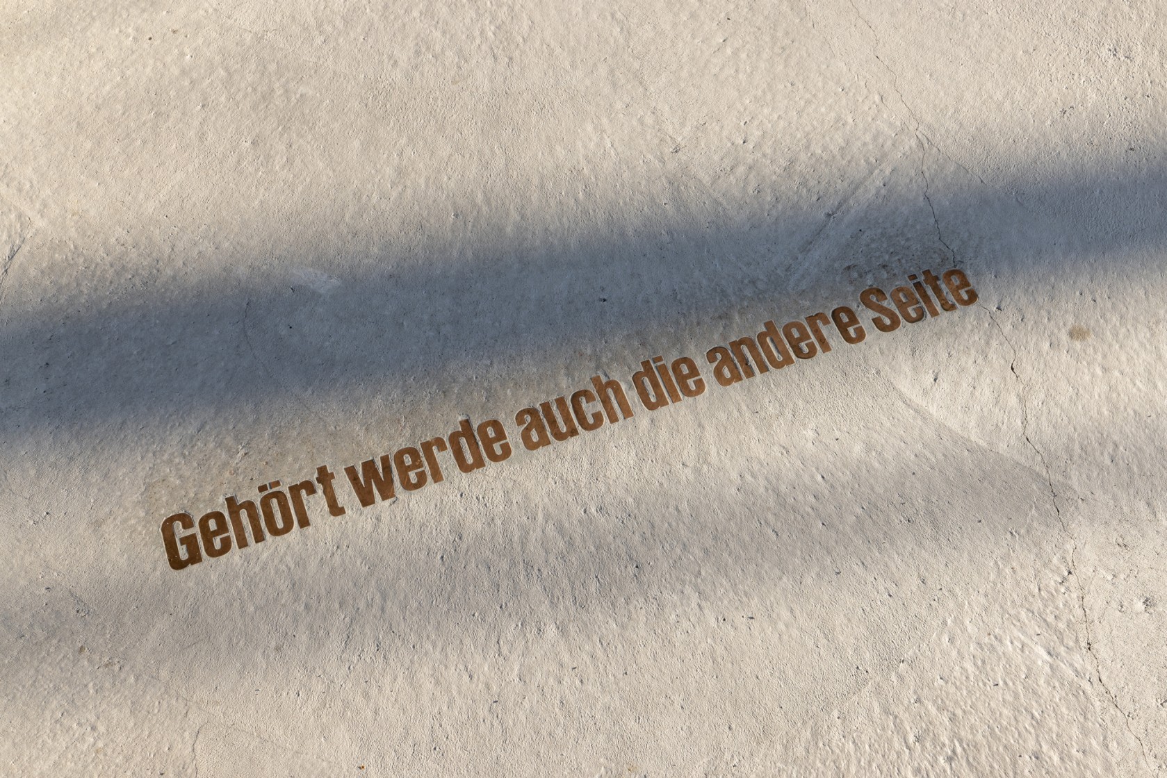 In Boden eingelassene Schrift: Gehört werde auch die andere Seite
