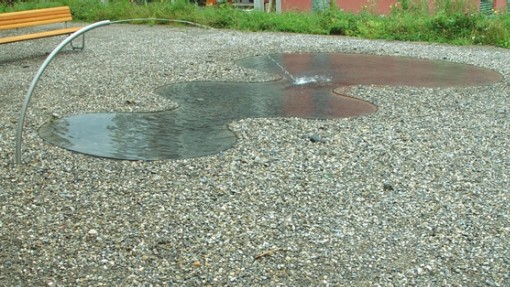 Wasserpfütze auf Kiesboden
