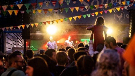 Garagenkonzert an einem Event Zuschauer trägt sein Kind auf den Schultern, um es die Konzertband sehen zu lassen